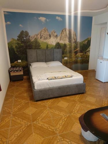 セヴァンにあるHayots Ojakhのベッドルーム1室(壁に絵画が描かれたベッド1台付)