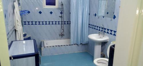 a blue and white bathroom with a toilet and a sink at KEKA House in Aswan