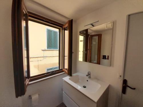 łazienka z umywalką, lustrem i oknem w obiekcie Il Rifugio del Pescatore w mieście Marciana Marina