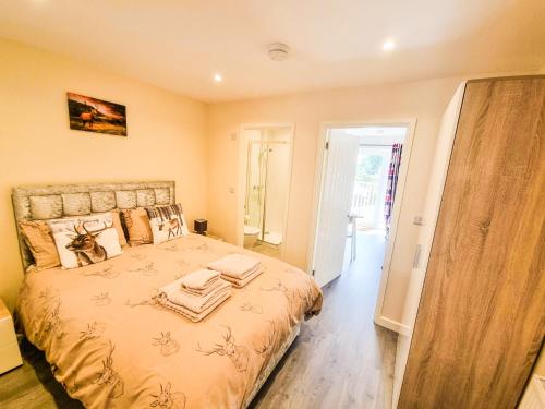 Deers Leap, A modern new personal double bedroom holiday let in The Forest Of Dean في Blakeney: غرفة نوم عليها سرير وفوط