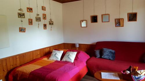 a bedroom with a bed and a couch and pictures on the wall at Studio sympa avec terrasse , maxi 4 pers.Briançon in Briançon