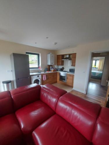 a living room with a red couch in a kitchen at The Mews in Inverness