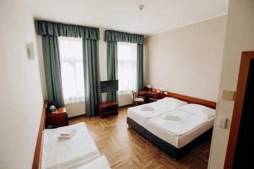 um quarto de hotel com duas camas e uma televisão em Alton em Praga