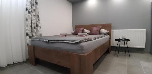 a bedroom with a bed with a wooden headboard at Apartments Jack in Bihać