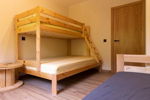 a wooden bunk bed in a room with a door at Espai Valldevia in Valldeviá