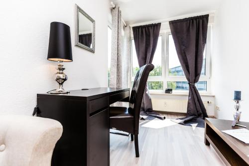 uma secretária preta e cadeira num quarto com uma janela em MY Messe & Business Home - by Lanxess Arena /Messe Cologne em Colônia
