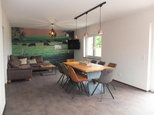 a living room with a table and chairs and a couch at Ferienwohnungen Am Kapellenberg Losheim am See in Losheim