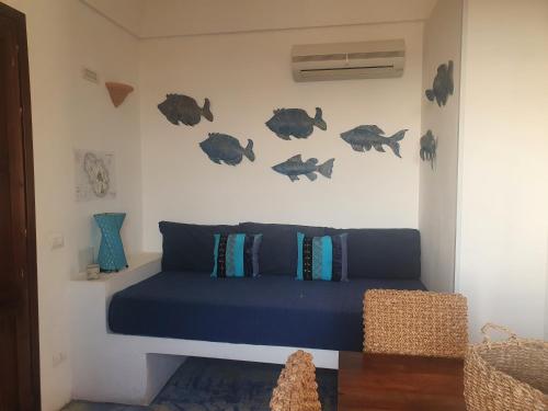 Un dormitorio con una cama azul con pescado en la pared en I dammusi zaffiro e ambra, en Pantelleria