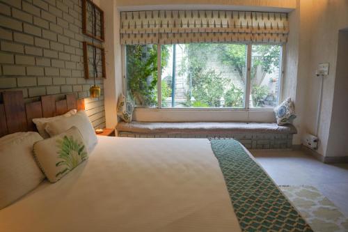 Un dormitorio con una cama grande y una ventana en The Bougainvillea Bed & Breakfast, en Amritsar