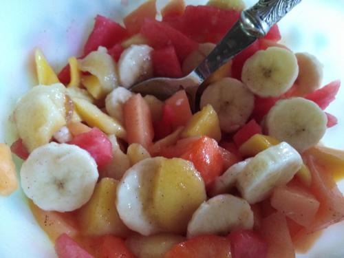 a plate of fruit and vegetables with a fork at Chalet La Bachole in Charancieu