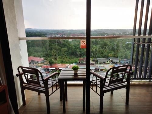 uma mesa e duas cadeiras em frente a uma grande janela em Kiki Homestay @ Timurbay, Kuantan em Kampung Sungai Karang