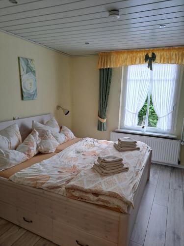 een groot bed in een slaapkamer met een raam bij MINGERS Huus in Neuharlingersiel