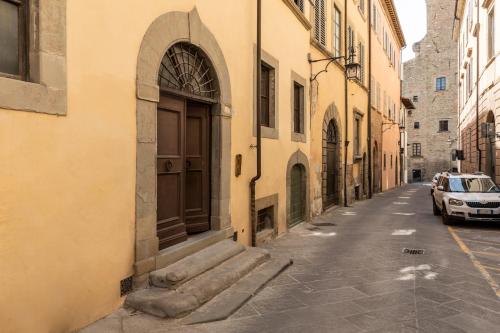 an alley with a door and a car on a street at CHIAROMANNI SUITE in Arezzo