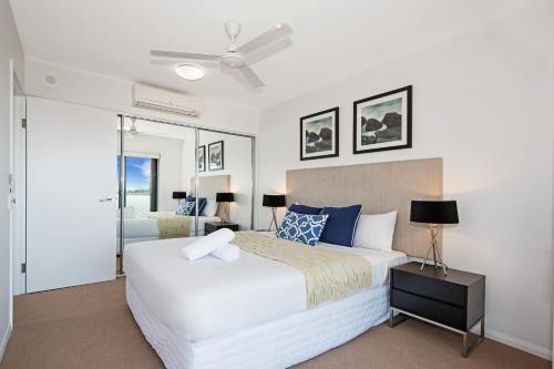 a bedroom with a bed and a ceiling fan at Allure Hotel & Apartments in Townsville