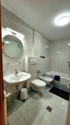 a bathroom with a sink and a toilet and a tub at Apartment Stella in San Lorenzo di Sebato