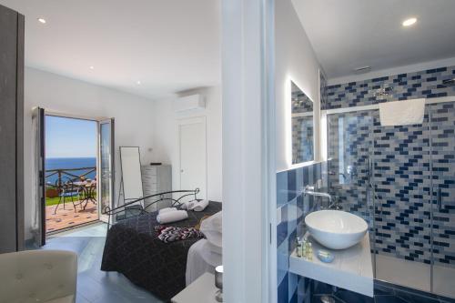 La salle de bains est pourvue d'un lavabo et offre une vue sur l'océan. dans l'établissement Villa Euriclea, à Praiano