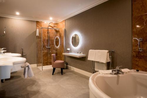 a bathroom with a tub and a sink and a bath tub at Harvey's Point in Donegal