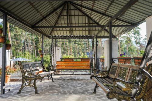 a group of benches sitting on a patio at Natali Hotel in Borjomi