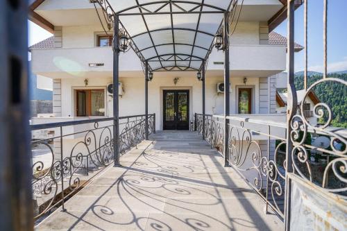 a house with a balcony with a gate at Natali Hotel in Borjomi