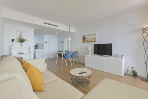 a living room with a white couch and a tv at Apartamento de lujo vista mar en Torrox Costa in Torrox Costa