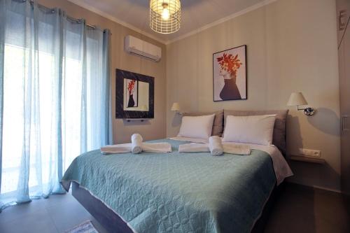 a bedroom with a large bed with towels on it at Matoulas Luxury Apartment in Nafplio
