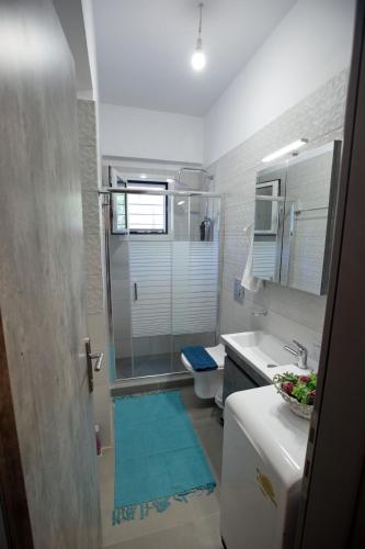 a bathroom with a sink and a toilet and a mirror at Matoulas Luxury Apartment in Nafplio