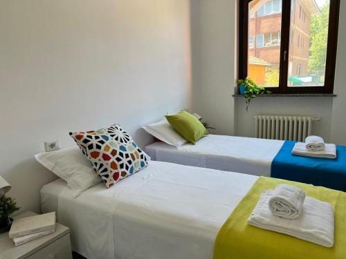 Habitación con 2 camas y ventana en Bnbook Olona-Fiera Milano, en Pero