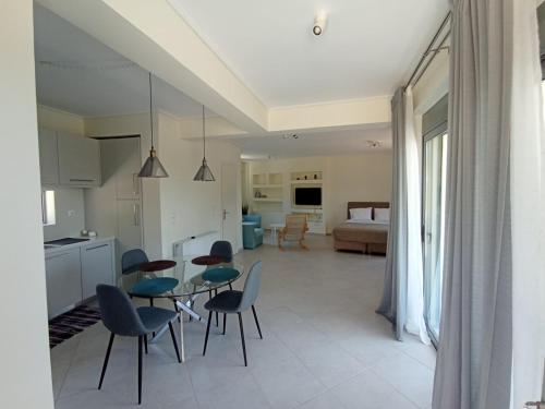 a kitchen and dining room with a table and chairs at Andi's Studio Porto Rafti in Porto Rafti