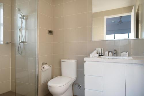 a bathroom with a toilet and a sink and a shower at Allure Hotel & Apartments in Townsville