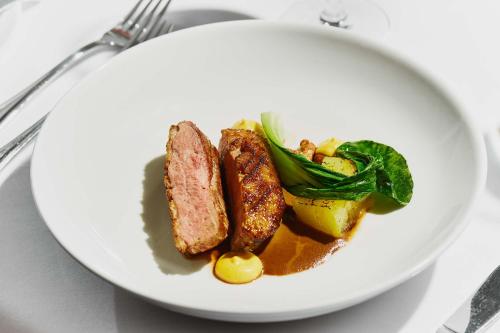 a white plate of food with meat and vegetables at Harvey's Point in Donegal