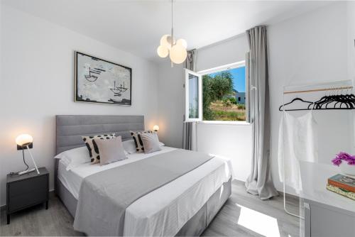 a white bedroom with a bed and a window at Villa Maris in Mlini