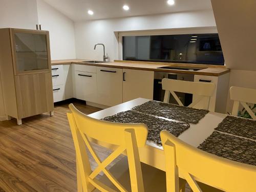 a kitchen with a table and chairs and a refrigerator at Apartment Židana marela - Attic with a View in Kranjska Gora