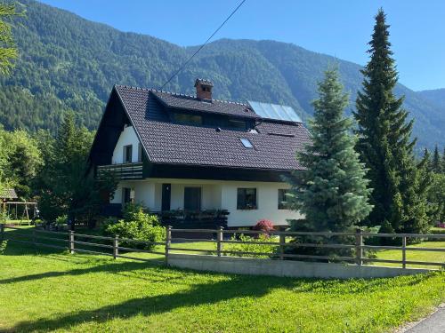 a house in a field with mountains in the background at Apartment Židana marela - Attic with a View in Kranjska Gora