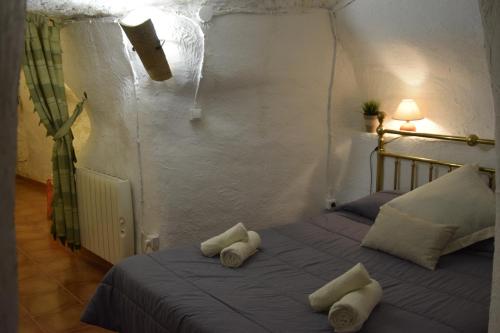 1 dormitorio con 1 cama con toallas en Casa Cueva Alegría, en Valdeganga