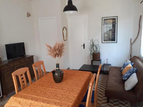 - une salle à manger avec une table et un canapé dans l'établissement Maisonnette proche de la plage, à Tarnos