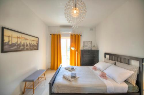 una camera da letto con un letto grande e un lampadario di Charming 2 bedroom apartment close to Junior College ETUS1-1 a Msida