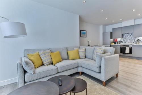 a living room with a gray couch and yellow pillows at Finest Retreats - No15 Belle House in Filey