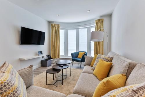 a living room with a couch and a tv at Finest Retreats - No15 Belle House in Filey