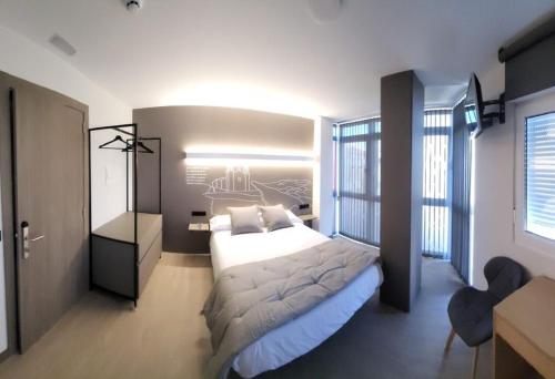 a bedroom with a large bed and a large window at HOSTAL HABITAT MUXIA II in Muxia
