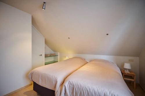 a small bedroom with a bed in a attic at Casa Jacaranda in Westvleteren