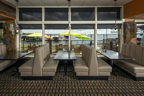 a restaurant with tables and chairs and a view of the water at Holiday Inn Detroit Lakes by IHG in Detroit Lakes