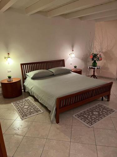 a bedroom with a large bed with two tables and two lamps at La casa di Ladì in Scilla