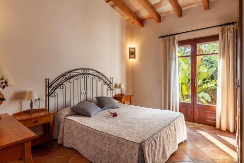 a bedroom with a bed and a large window at Finca Es Turo in Santanyi