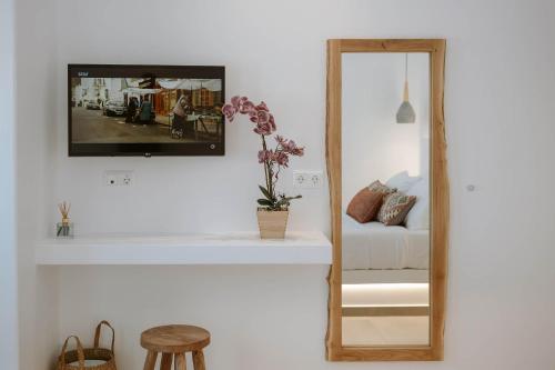 a mirror sitting on a wall next to a bed at Nautica suites - Grand Suite with jacuzzi in Andiparos