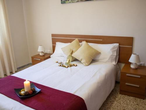 a bedroom with a white bed with a candle on it at Puesta de Sol Rentals 3AJ in Playa de San Juan