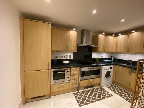 a kitchen with wooden cabinets and a stove top oven at Fabulous 2 bed apartment in Vauxhall in London