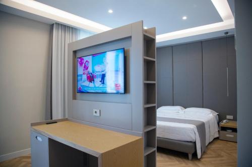 a room with a bed and a flat screen tv at Hotel Ristorante Aeclanum in Mirabella Eclano