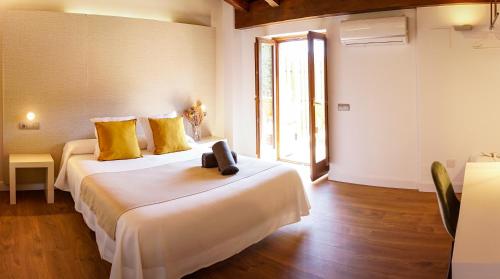 a bedroom with a large white bed with yellow pillows at Hotel Mas Mariassa in Pratdip
