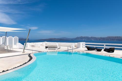 a swimming pool with chairs and a view of the water at Avant Garde Suites in Akrotiri