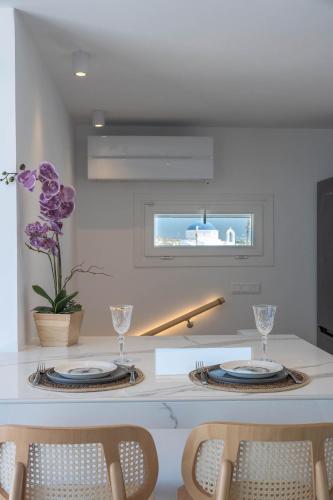 a kitchen with a table with two plates and chairs at Nautica suites - Grand Suite with jacuzzi in Andiparos